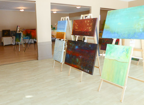 marie gelinas giles abstract acrylic paintings with CAC on easels in center of room