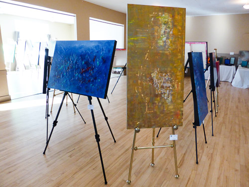 marie gelinas giles abstract acrylic paintings with CAC on easels in center of room